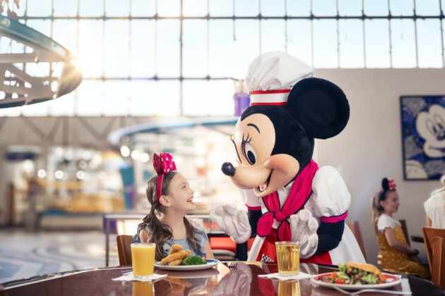 A young girl meets Minnie Mouse during a dining meet and greet