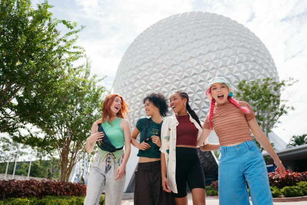 Four friends walking in front of the EPCOT ball