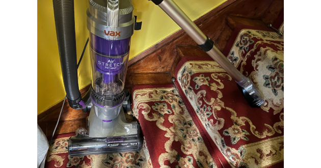Mumsnet home editor Poppy O'Neill testing the VAX Air Stretch Pet Max Corded Upright Vacuum Cleaner