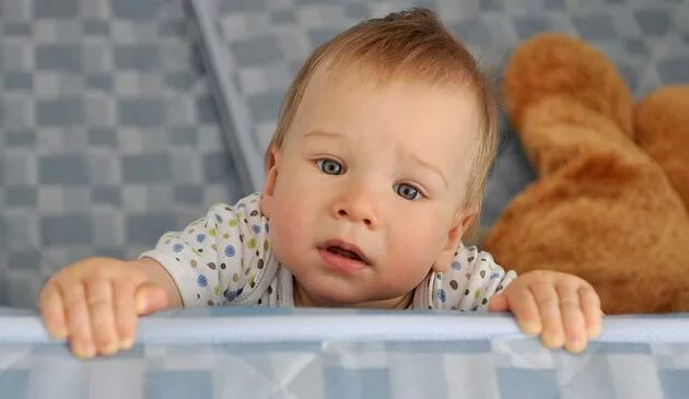 Baby standing up in cot