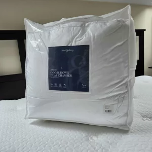 The Soak & Sleep Goose Down Mattress Topper in its bag