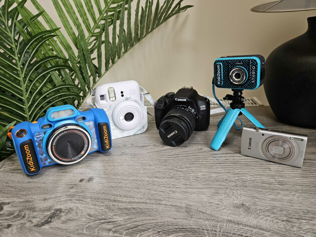 A collection of children's cameras, including VTECH Kidizoom, instax, Canon, VTECH Kidizoom Studio and the Canon IXUS