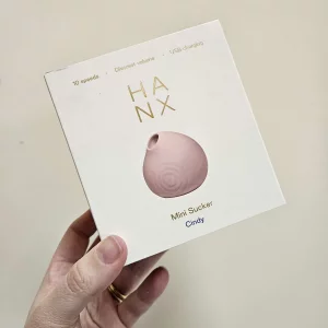 A hand holding the HANX Cindy against a wall