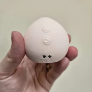 A hand holding the HANX Cindy against a wall