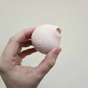 A hand holding the HANX Cindy against a wall