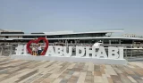 Rebecca Roberts and her two children sit atop the I love Abu Dhabi sign in Al Qana marina in Abu Dhabi