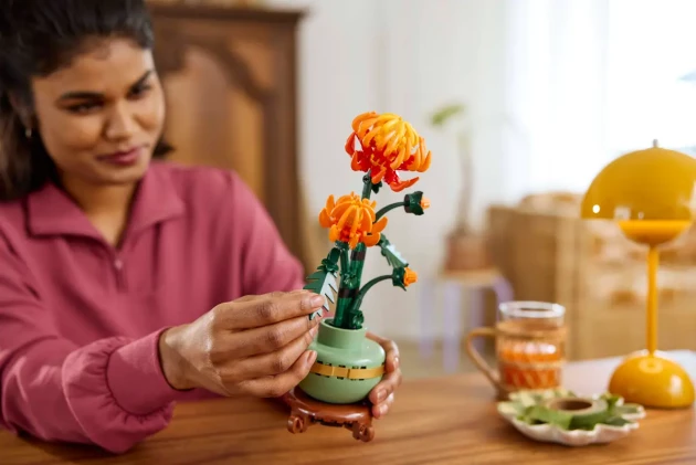 LEGO's Botanical Collection Chrysanthemum being built by a woman