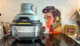 Ninja CRiSPi portable cooking system on kitchen counter next to decorative art and Marmite jar