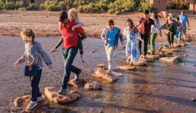 a group of people walk along stepping stones