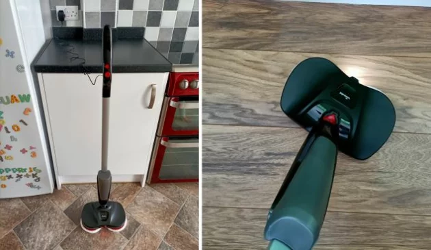Two images side-by-side show the full length of the black and red electric soray mop being charged in a kitchen with brown vinyl flooring, white cupborads and a red oven. The second photo shows a close up of the black floor head spraying water on the same brown vinyl flooring