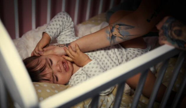 a toddler awake and distressed at night, while her mother tries to comfort her