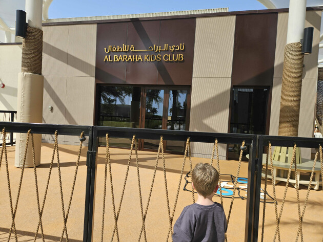 ERTH Abu Dhabi hotel's kids club, Al Baraha, with my son standing outside of it
