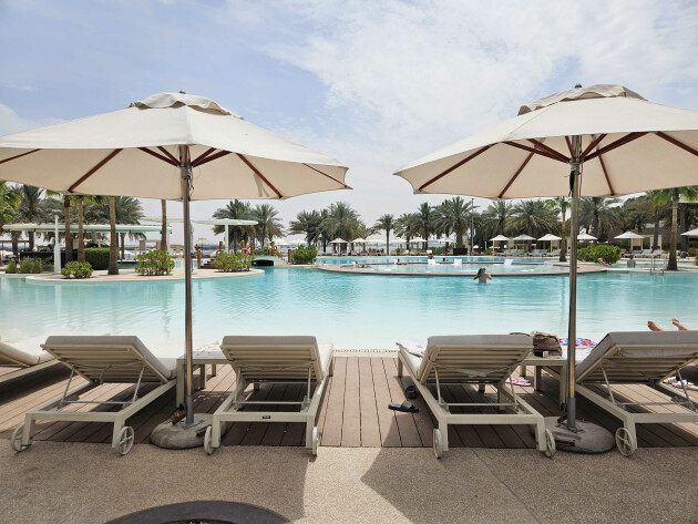 A view of the pools from behind sunbeds at ERTH Abu Dhabi hotel