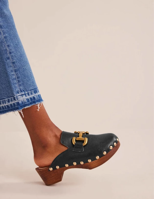 A model wearing black clogs by Boden