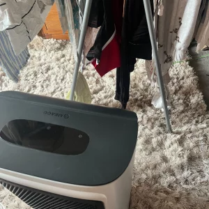 Journalist Poppy O'Neill hand testing the Meaco DD8L Pro Desiccant Dehumidifier