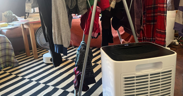 Mumsnet editor Poppy O'Neill hand testing the Devola 12L Compressor Dehumidifier DV12L