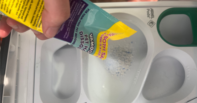 Mumsnet home editor Poppy O'Neill testing the Vamoosh Pet Hair Dissolver and Washing Machine Cleaner