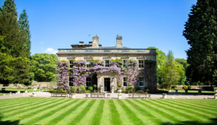 a grand country home covered in wisteria