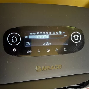 Journalist Poppy O'Neill hand testing the Meaco DD8L Pro Desiccant Dehumidifier