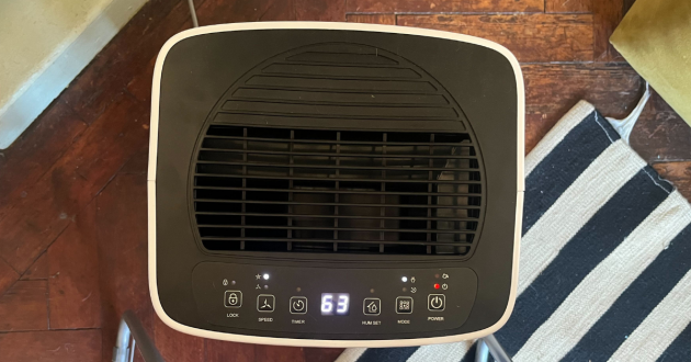 Mumsnet editor Poppy O'Neill hand testing the Devola 12L Compressor Dehumidifier DV12L