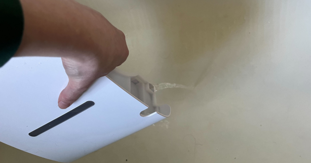 Mumsnet editor Poppy O'Neill hand testing the Devola 12L Compressor Dehumidifier DV12L