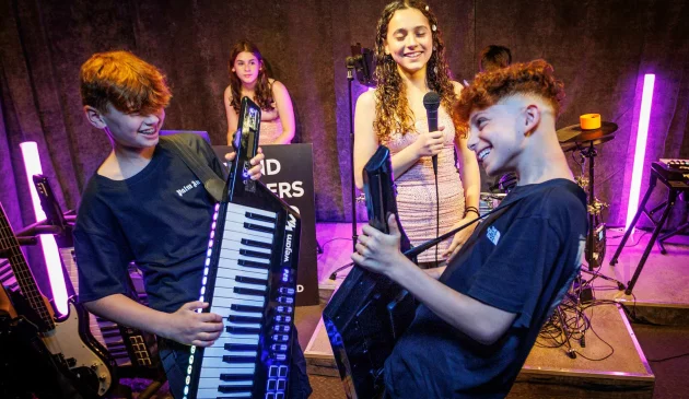 A group of young teenagers play in a band together at WeJam in London