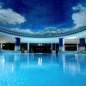 a hotel pool with a ceiling painted like the night sky