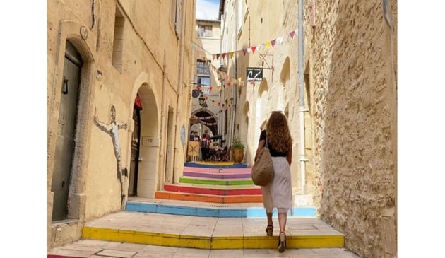 A woman walks up rainbow coloured steps in Montpellier, France
