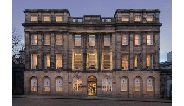 the facade of a grand building, brightly lit from within