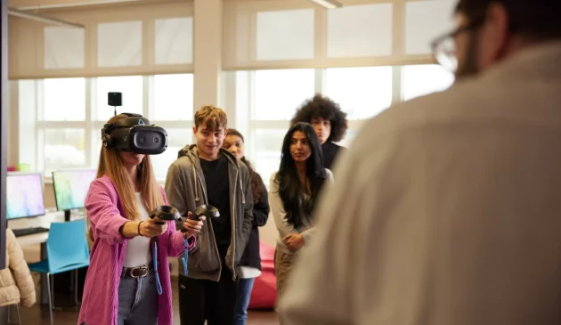 A group of further education students using a VR headset in class