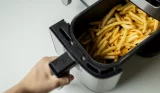 Cooked chips in air fryer basket, lead image for how to clean an air fryer article