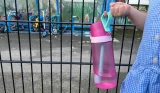 A girl holds the Air Up Mini Sipper bottle