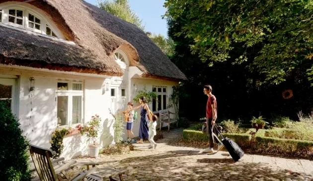 family walking into cottage