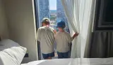 Two young children look out of the window from the Aloft Manchester hotel