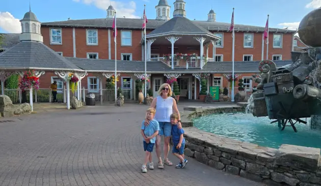 Rebecca stands with her two children outside Alton Towers Hotel beside the fountain