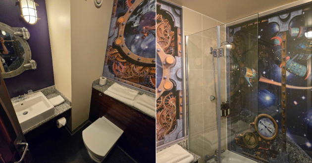 Moon Voyage bathroom with toilet, sink and shower over the bath, surrounded by space-themed artwork