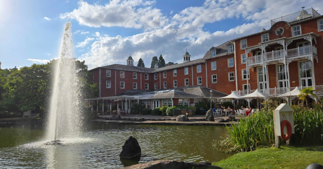 Rear of Alton Towers Hotel across the lake, with the fountain and outdoor seating visible