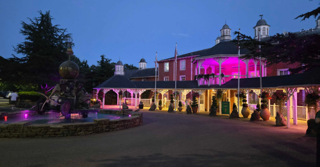 Alton Towers Hotel illuminated with pink lights after dark