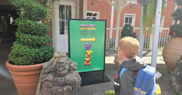 Child looking at a Minecraft Meet the Mobs direction sign outside Alton Towers Hotel