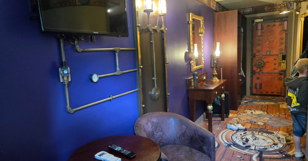 Moon Voyage Room with purple walls, wall-mounted television, dressing table and themed entrance door