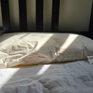 A view of the Ava Innes pillow in the sun on the bed