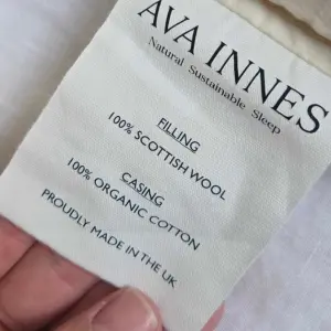 A close up of the care label on the Ava Innes Luxury Wool & Organic Cotton Bed Pillow
