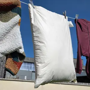 A view of the Ava Innes pillow hanging on a washing line