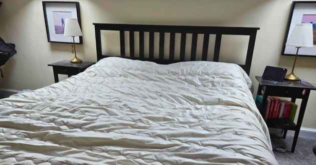 Super king Ava Innes Cashmere and Wool Duvet fully spread across a UK bed frame, showing coverage and drape
