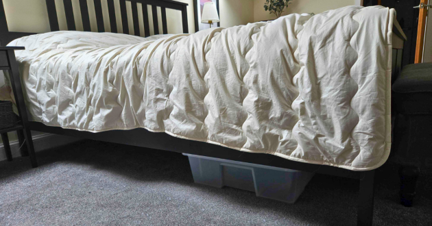 Side view of the Ava Innes duvet draping over the edge of a super king bed, illustrating thickness and weight