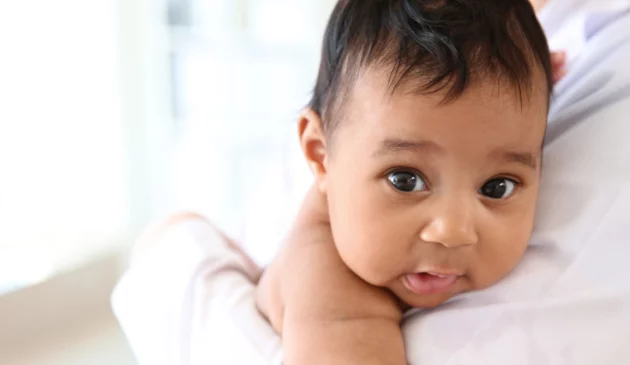 Baby being held in adult's arms
