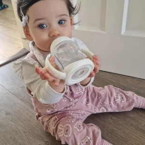 Baby holding NUK First Choice Learner Bottle