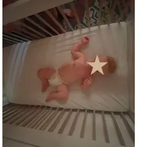 baby in silver cross valencia cot bed