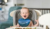 baby in highchair with solid food