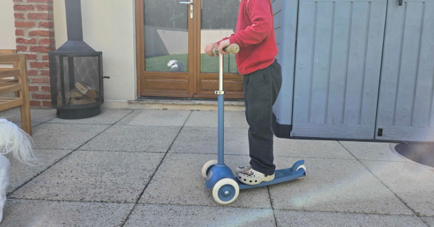 Child riding Banwood Eco Scooter on garden slabs